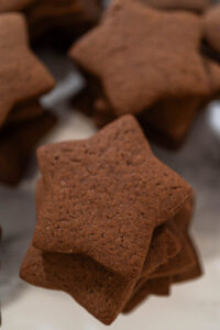Perfectly Icing Star Cookies with Royal Icing - Arina Photography Stack of plain chocolate star cookies made from chocolate gingerbread dough, perfect for holiday decorating or gifting.